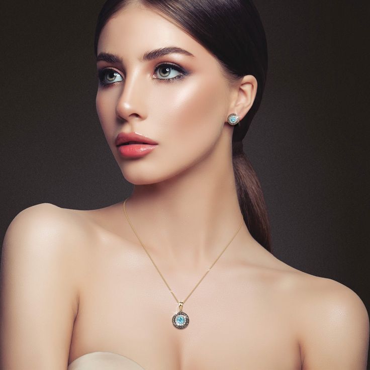 Introducing the timeless beauty of our Blue Topaz Horizon Pendant, crafted from the finest sterling silver, finished in 18k yellow gold, featuring a stunning blue topaz stone at the center. The blue topaz radiates a calming oceanic aura, surrounded by a halo of sparkling white Diamondeau®, flawless simulated diamond, adding a touch of sophistication. A second halo of brown shimmering gems with a black rhodium finish, adds an extra layer of glamor to this exquisite piece. This pendant is a versat Blue Topaz Stone, Latest Jewellery, Topaz Stone, Black Rhodium, Signature Design, Timeless Beauty, Blue Topaz, Topaz, Aura