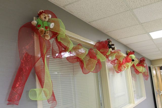 some red and green ribbons are hanging on the window sill in an office building