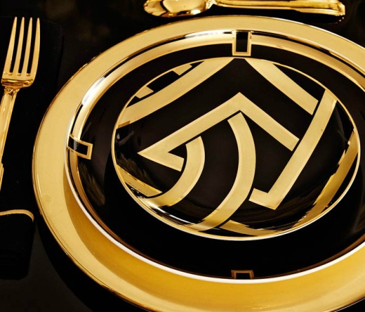 a black and gold table setting with silverware