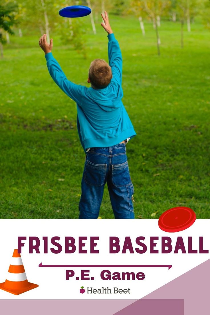 a young boy is throwing a frisbee in the park with his hands up