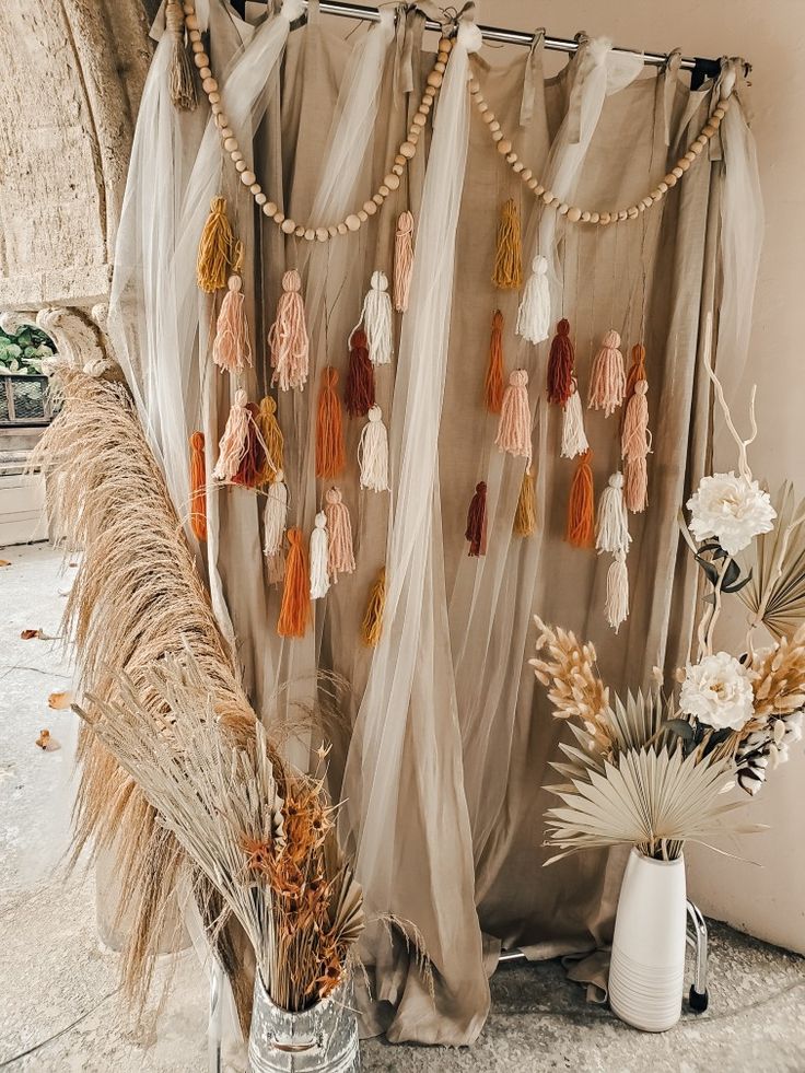 a curtain with tassels hanging from it next to some flowers and other items