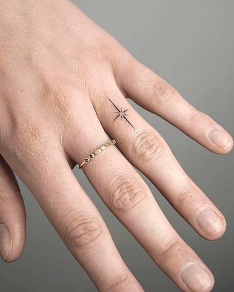 a person's hand with a cross ring on it