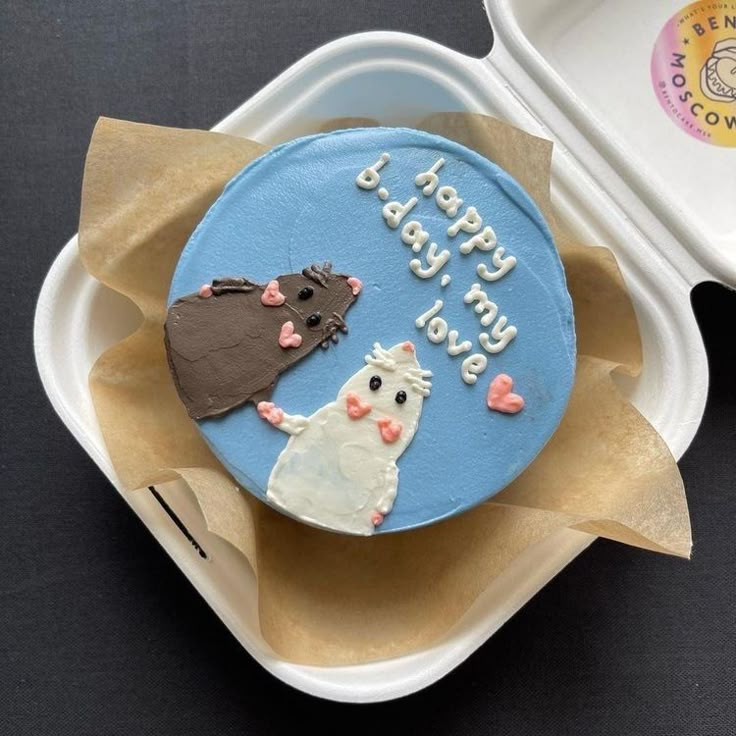 a birthday cake in the shape of a cat and a mouse on top of it