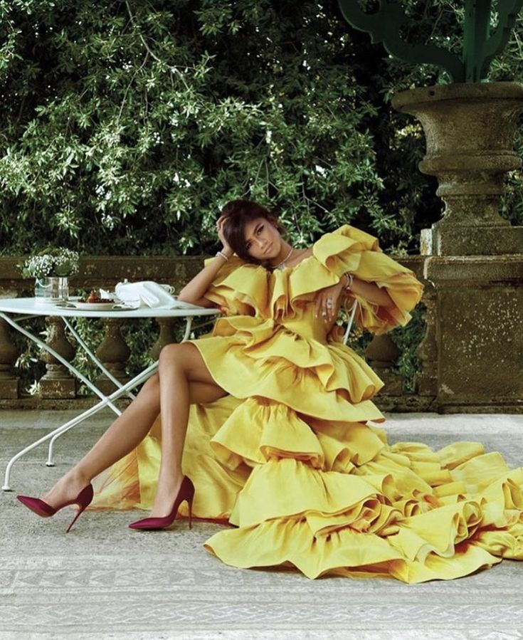 a woman in a yellow dress sitting on the ground