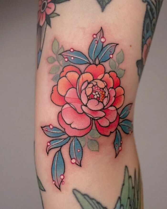 a woman's thigh with flowers and leaves on it