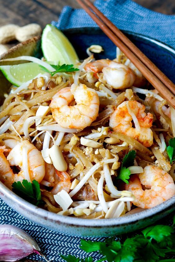 a bowl filled with shrimp and rice next to chopsticks