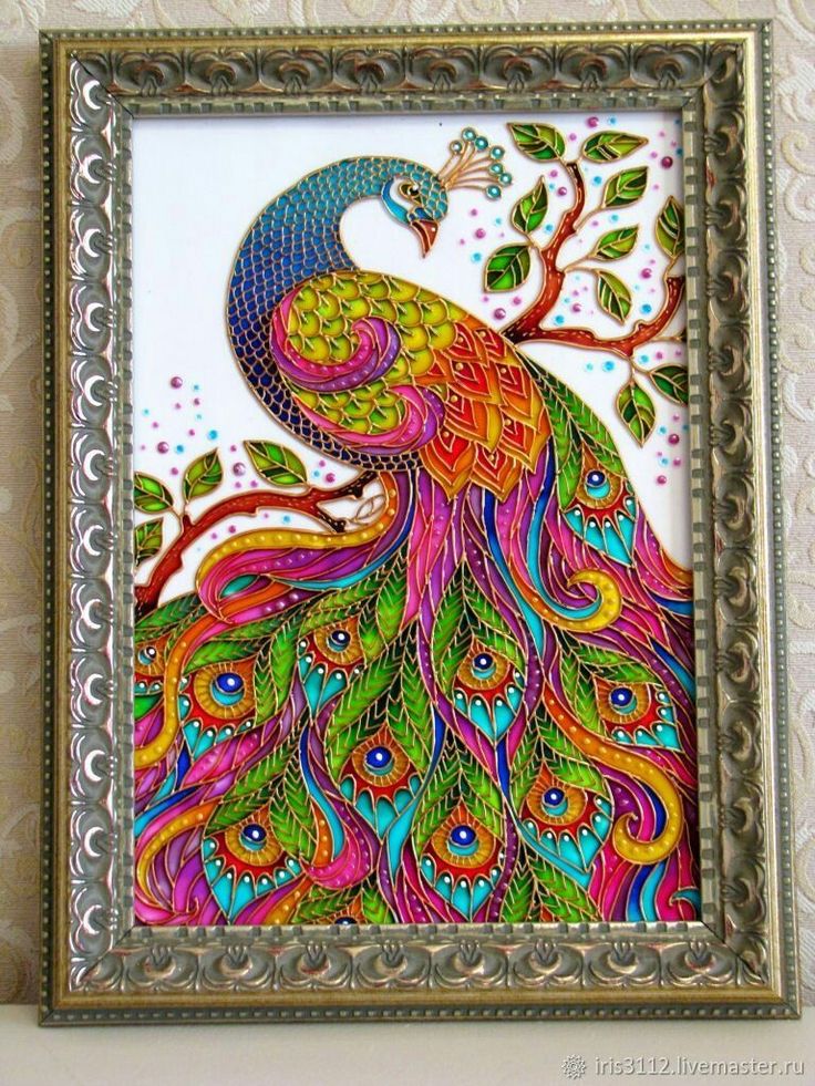 a colorful peacock sitting on top of a table next to a framed wall art piece