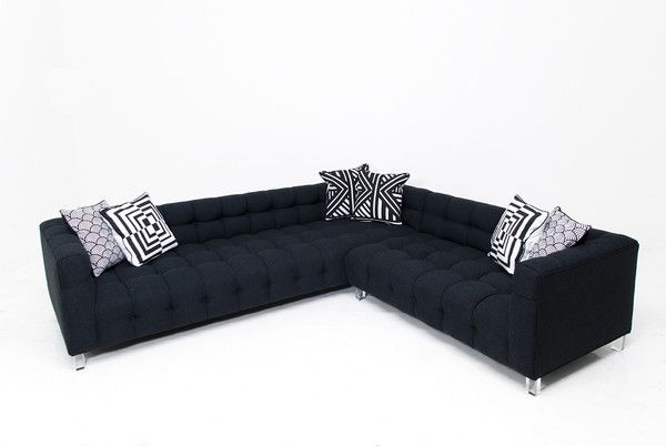 a black sectional couch with pillows on it