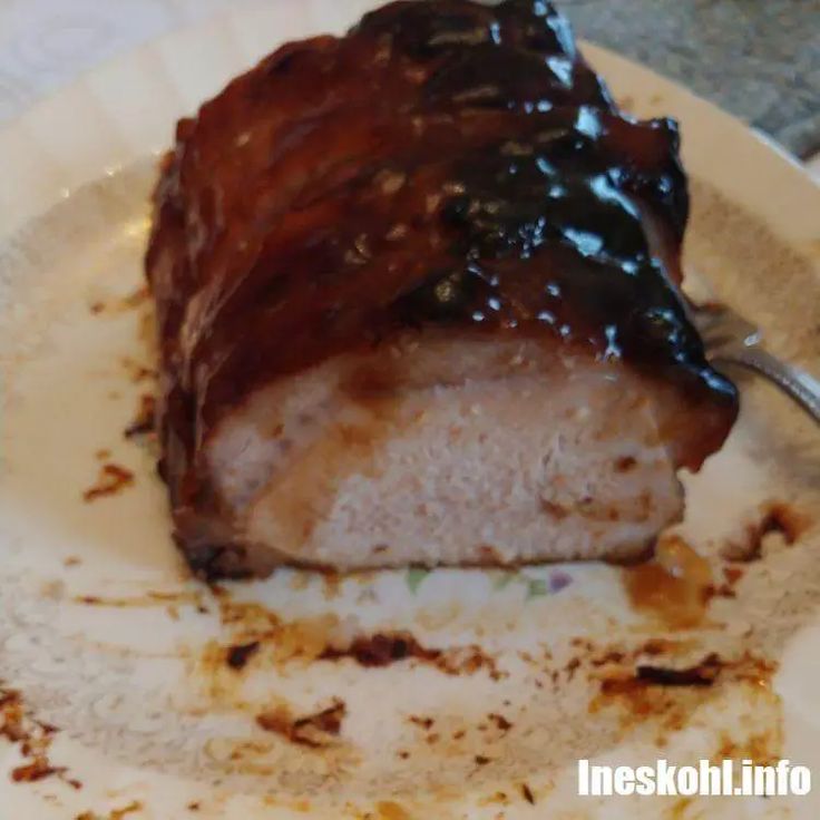 a piece of meat with sauce on it sitting on a plate