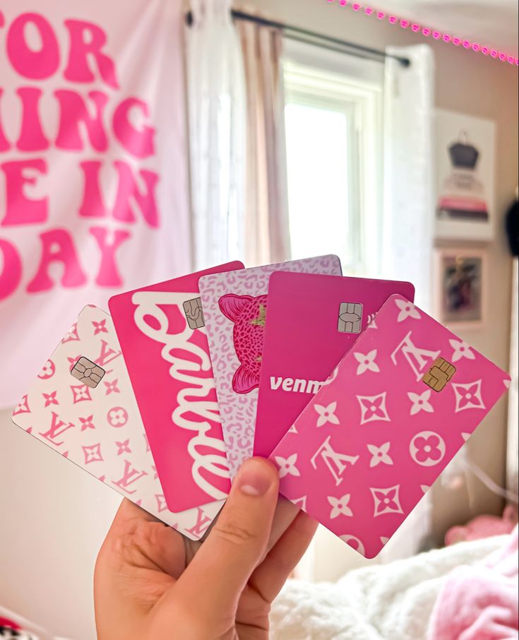 a person holding four pink cards in their hand with the words hello kitty on them