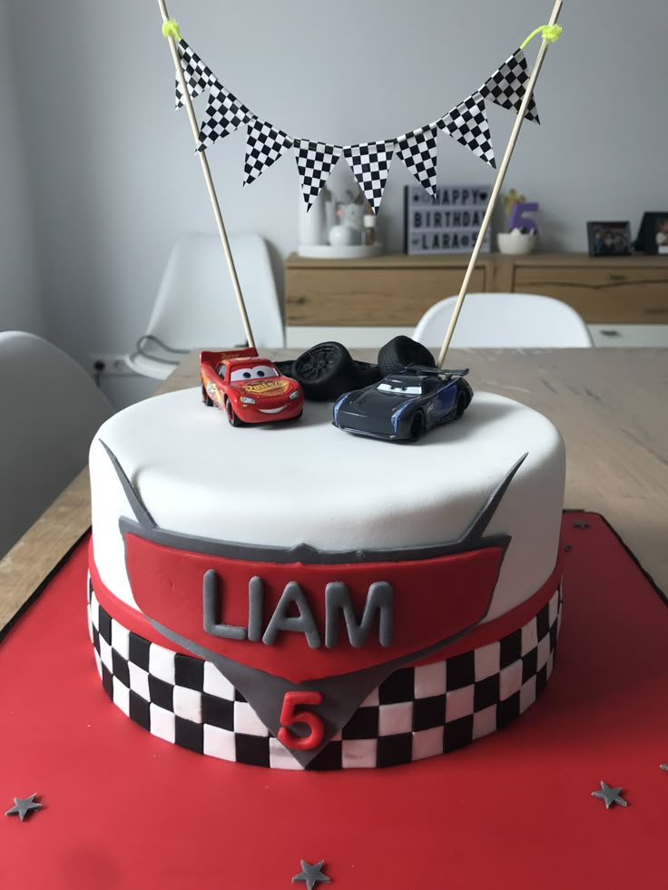 a birthday cake with cars and flags on top