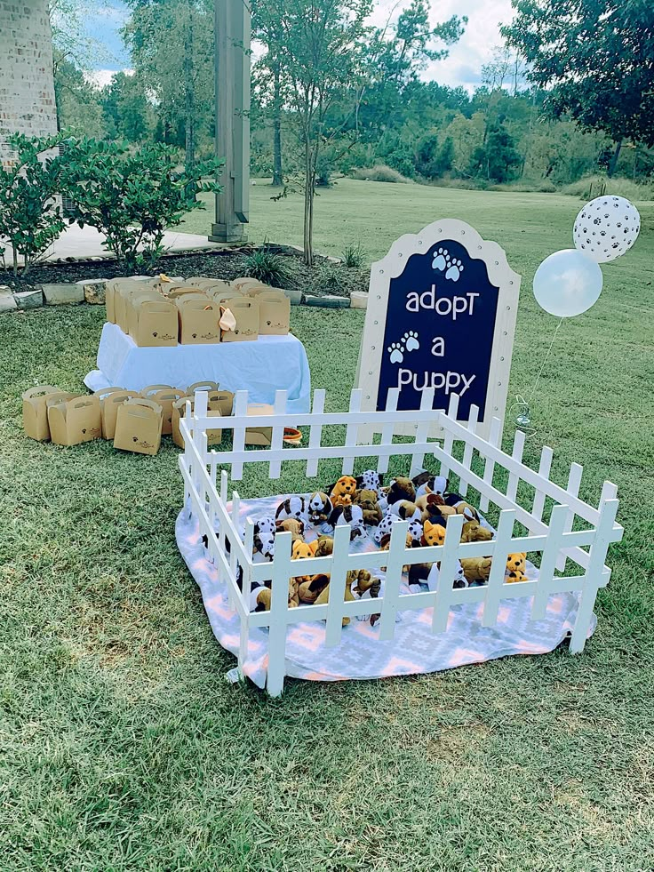 a dog themed birthday party with puppies in a basket and balloons on the grass