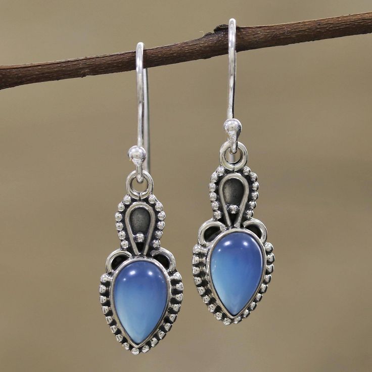 Considered by some to absorb negative energy, cool blue chalcedony is intriguing in these earrings from Alok Jain. Artisans set the cabochon gems in sterling silver bezels and surround them with silver rawa or granules. Contrasting oxidization adds interest to the unique earring design. The earrings swing from sterling silver hooks. Rough Gemstone Ring, Raw Opal Ring, Chalcedony Earrings, Carnelian Pendant, Earrings Teardrop, Moonstone Earrings, Silver Dangle Earrings, Jewelry Show, Sterling Silver Dangle Earrings