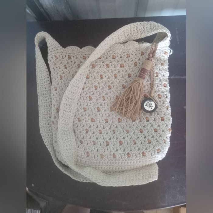 a white crocheted purse sitting on top of a table