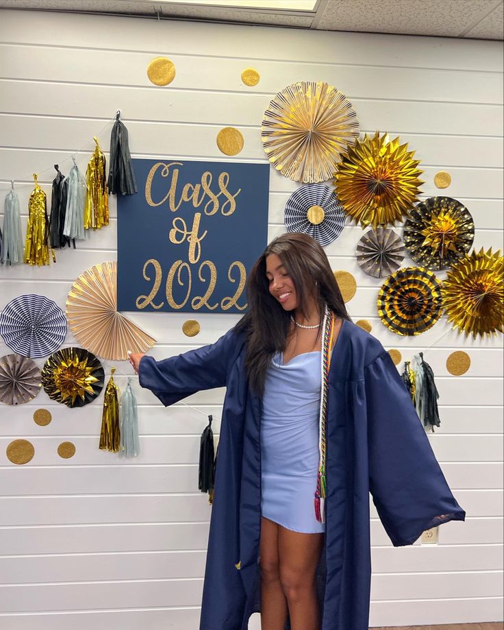 a woman standing in front of a graduation sign