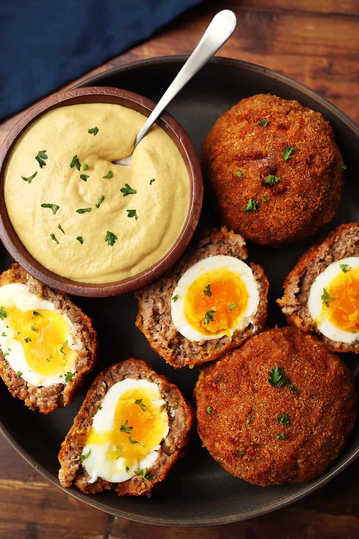 an image of some food on a plate with eggs and dip in the middle for dipping