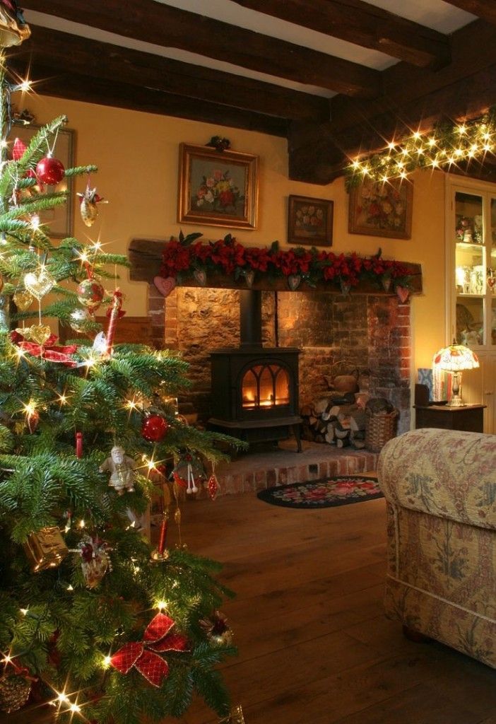 a living room decorated for christmas with lights on the tree and decorations around the fireplace