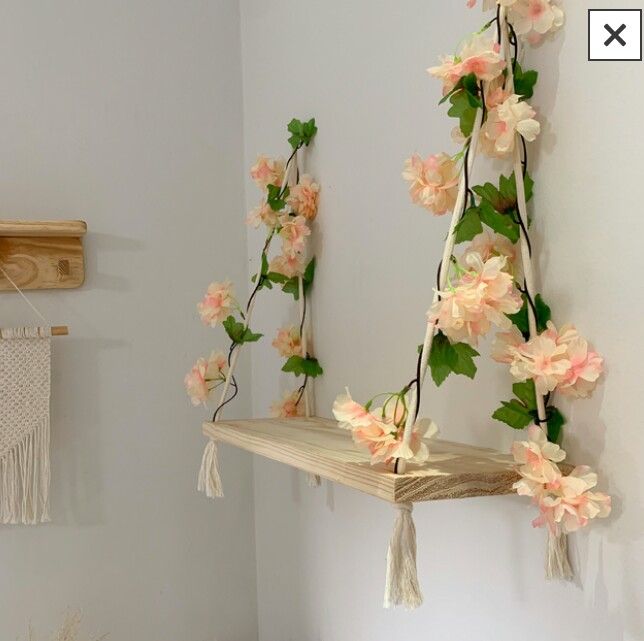 a shelf with flowers hanging from it in a room