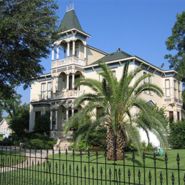 a large white house sitting on top of a lush green field