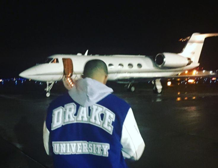 a man standing in front of an airplane at night