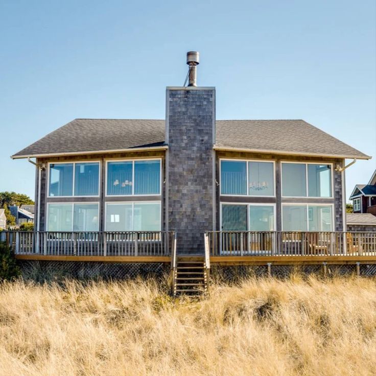 a large house sitting on top of a dry grass covered field