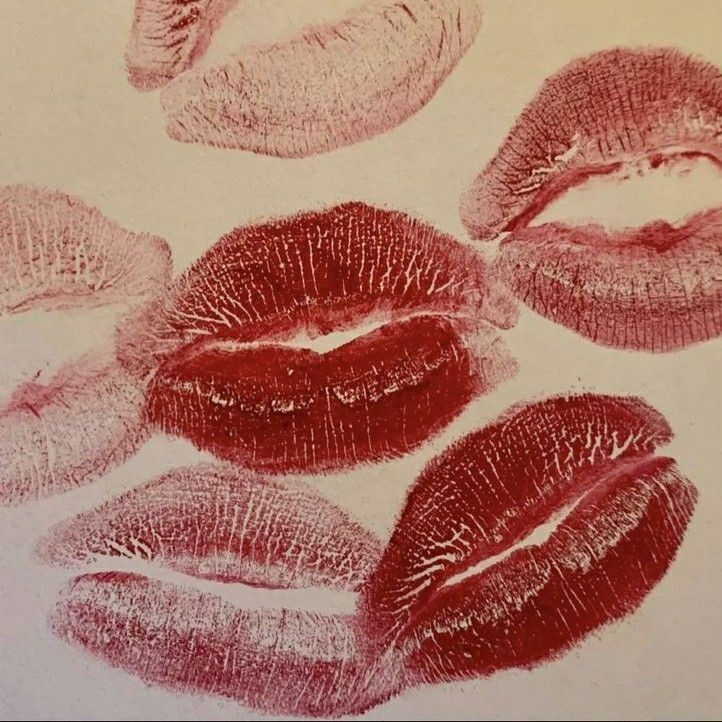 four lipstick imprints are shown in red, pink and grey ink on a white paper