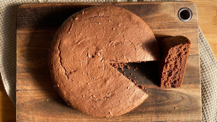 a chocolate cake on a wooden cutting board