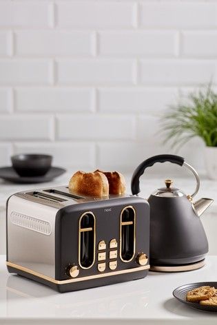 a toaster sitting on top of a white counter next to a plate with food