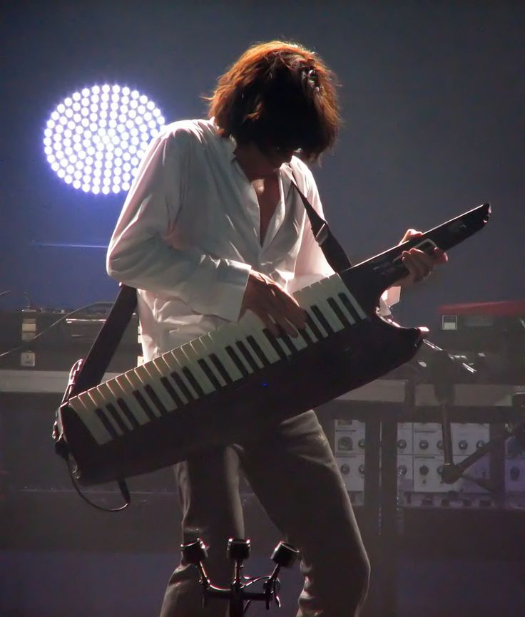 the man is playing an instrument on stage