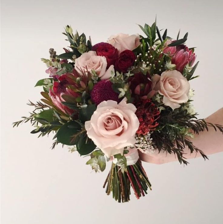 a person holding a bouquet of flowers in their hand