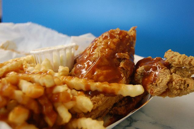 a close up of a plate of food with chicken and waffle fries on it