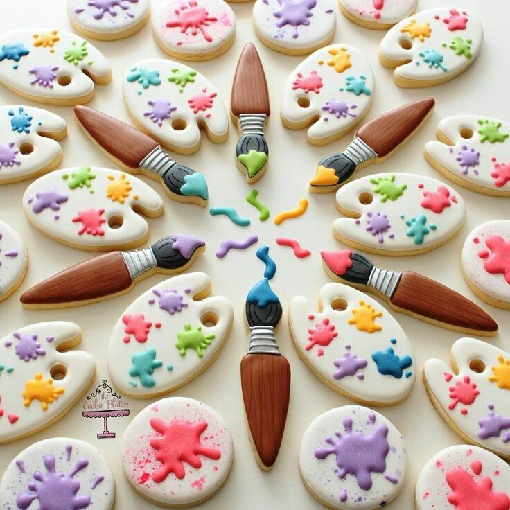 decorated cookies arranged in the shape of a circle with paintbrushes and crayons on them