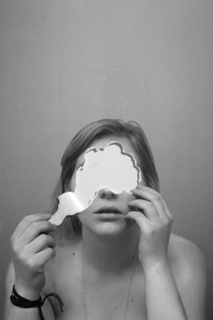 a woman holding up a mirror to her face