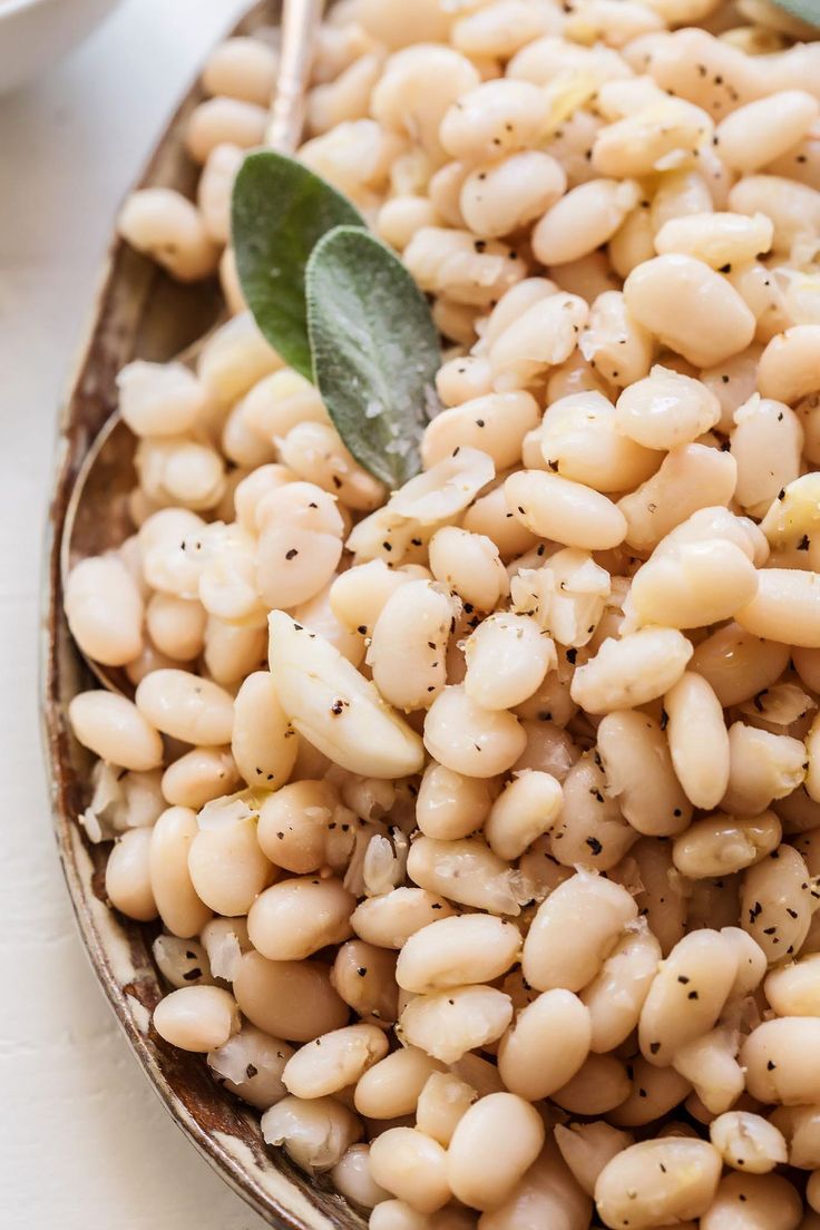 a plate filled with white beans and herbs