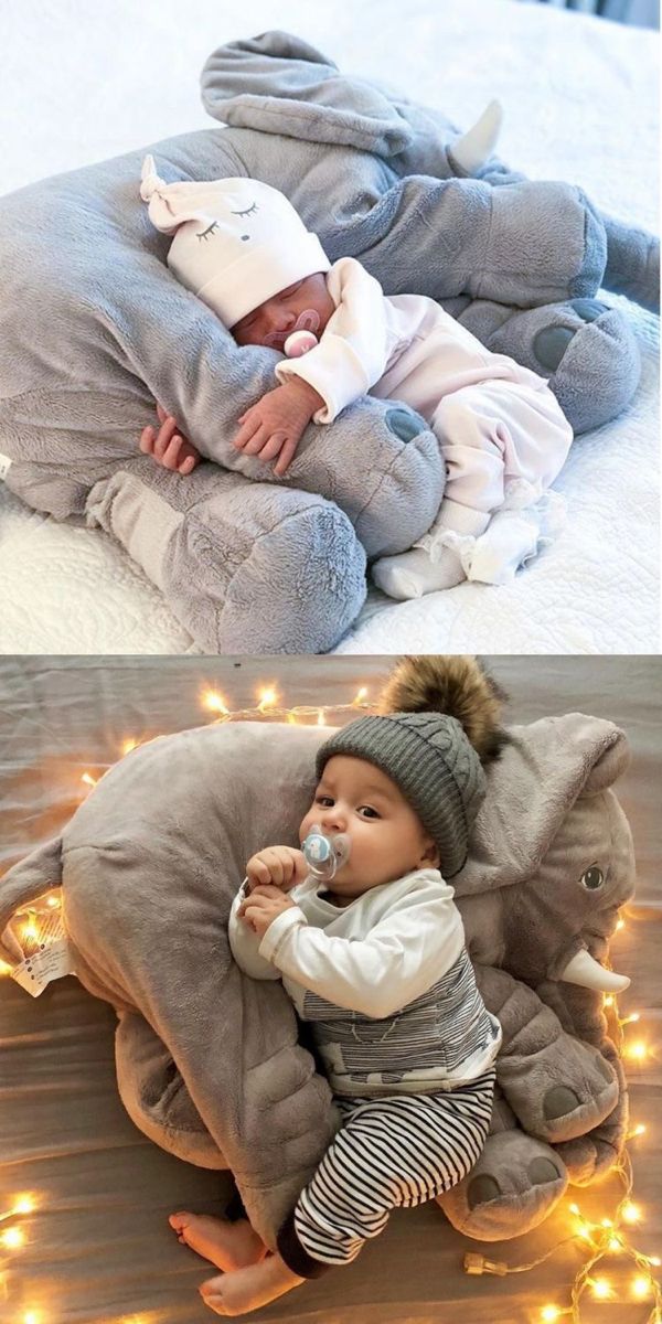 a baby is laying on top of an elephant pillow with lights around it and the bottom one has a pacifier in its mouth