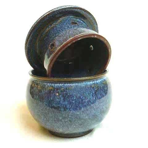 a small blue bowl with two lids on it