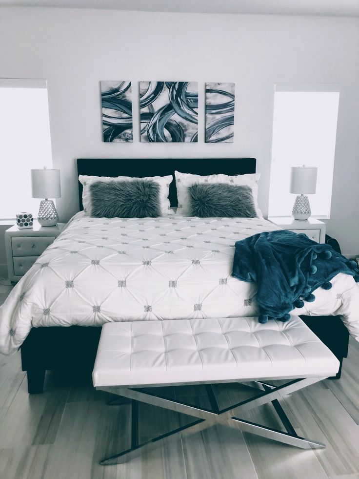 a white bed sitting in a bedroom on top of a hard wood floor