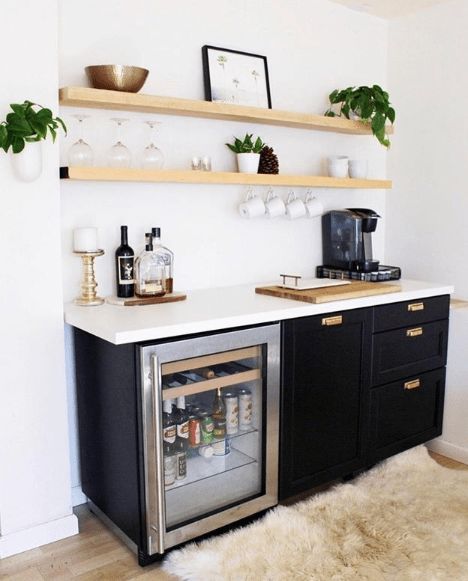 an instagramted photo of a kitchen with black cabinets and white countertops, including a refrigerator