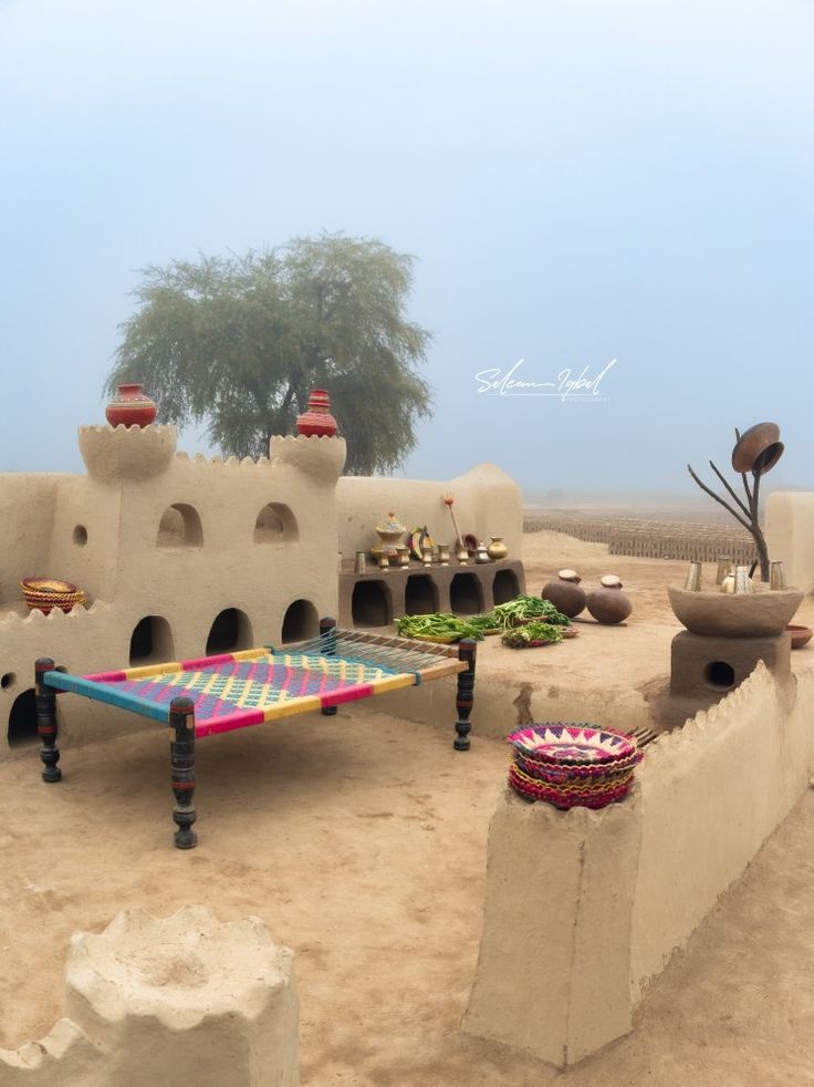 a colorful table sitting in the middle of an adobe - style building with potted plants