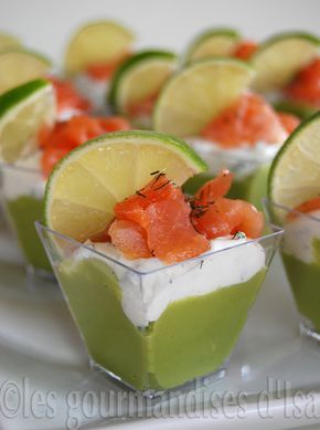 small cups filled with food on top of a white plate and garnished with limes