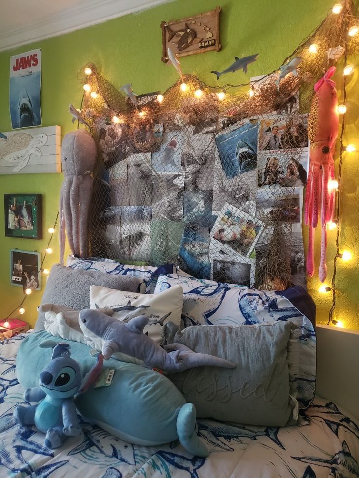 a bed with stuffed animals and lights on the headboard in a bedroom decorated for halloween