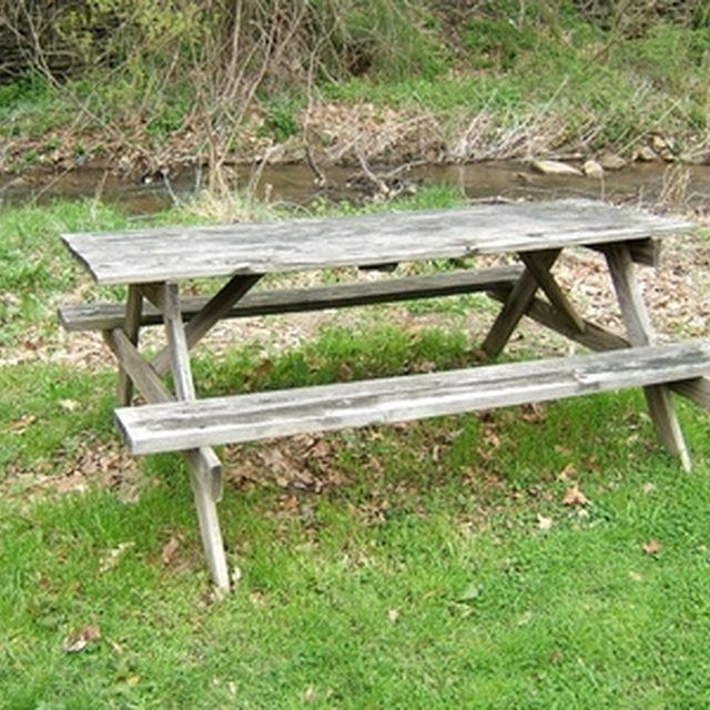 an old picnic table sitting in the grass