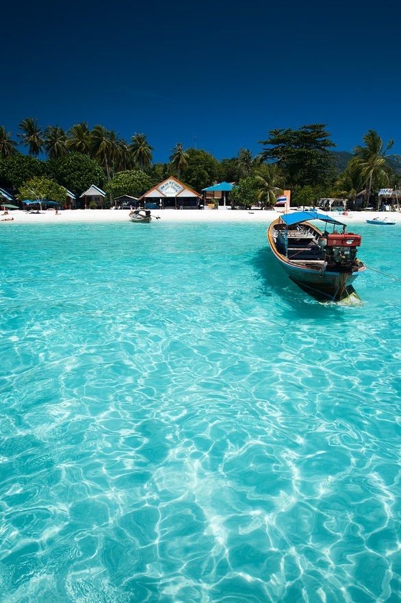 a small boat floating on top of a blue ocean