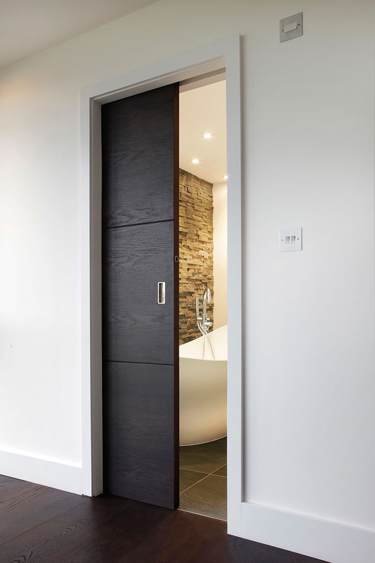 an open door leading to a bathroom with a tub in the background