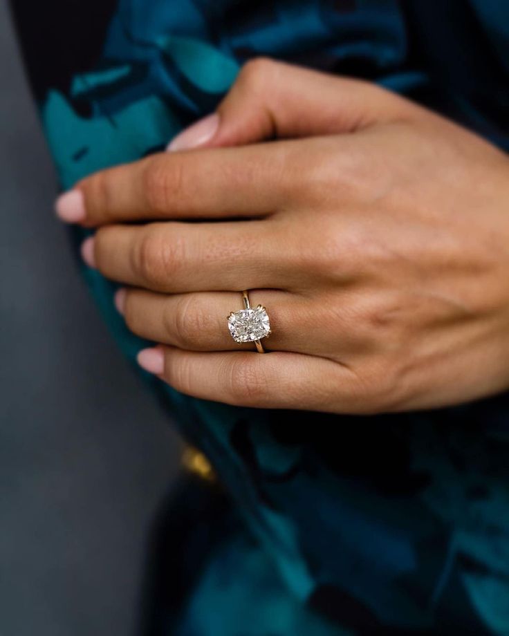 a woman's hand with a diamond ring on it