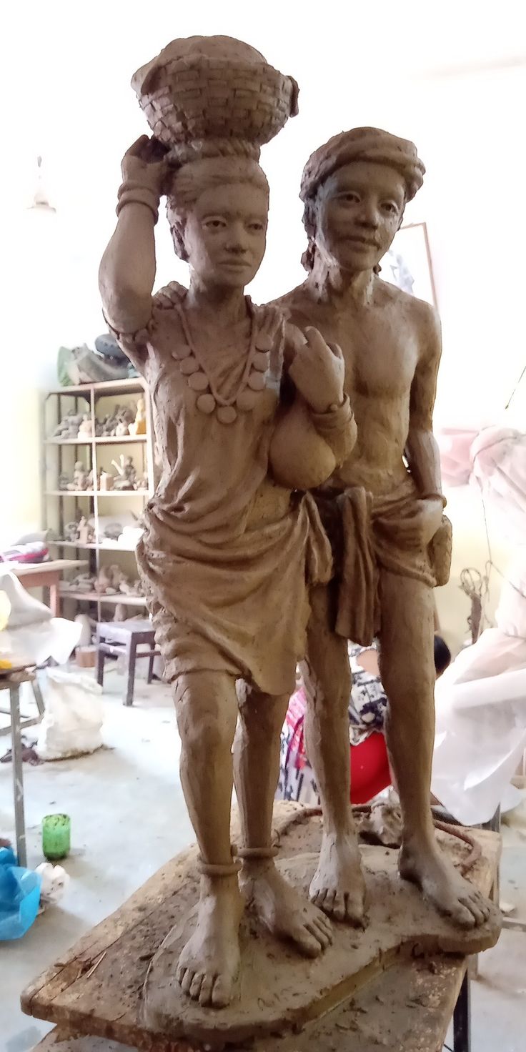 two statues sitting on top of a wooden table