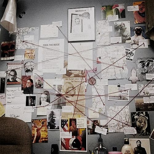 a wall covered in pictures and papers next to a chair