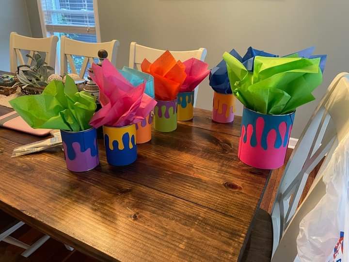 colorful paper flowers sitting on top of a wooden table