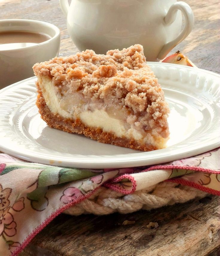 a piece of pie sitting on top of a white plate next to a cup of coffee