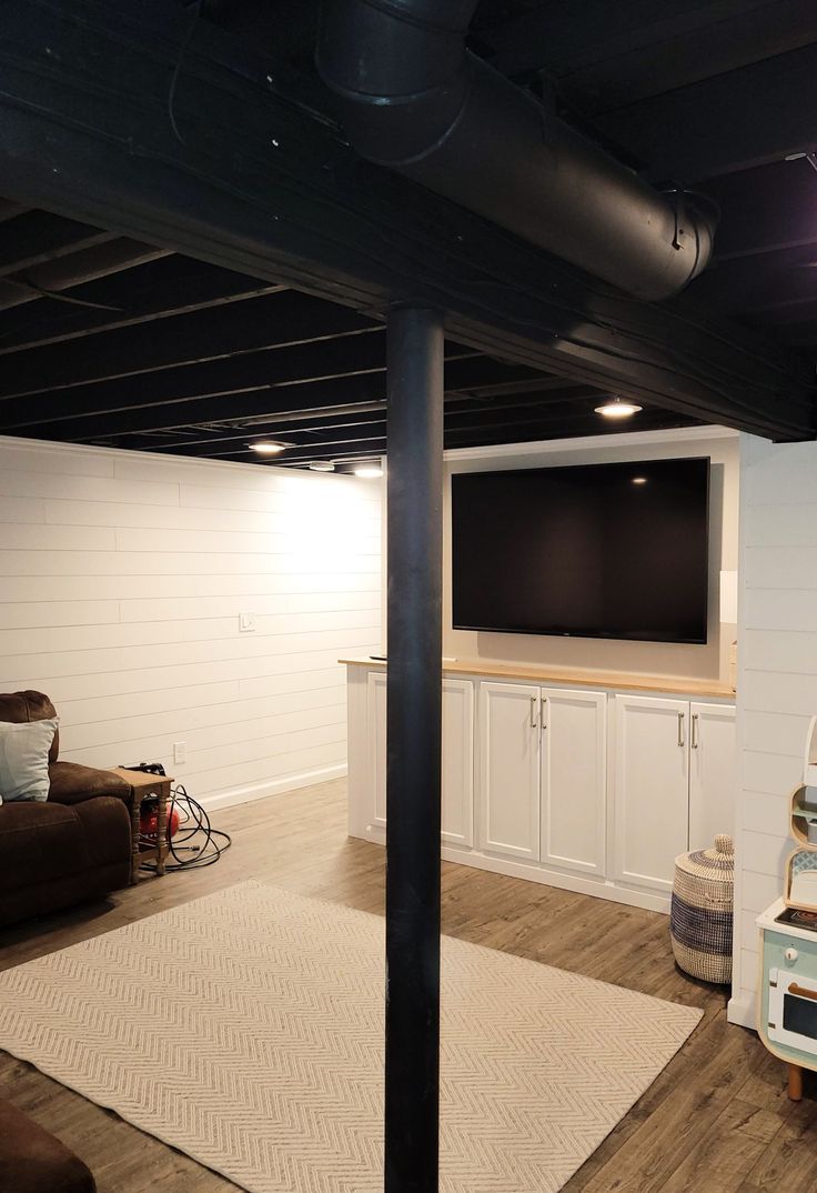 a living room filled with furniture and a flat screen tv mounted to the wall above it